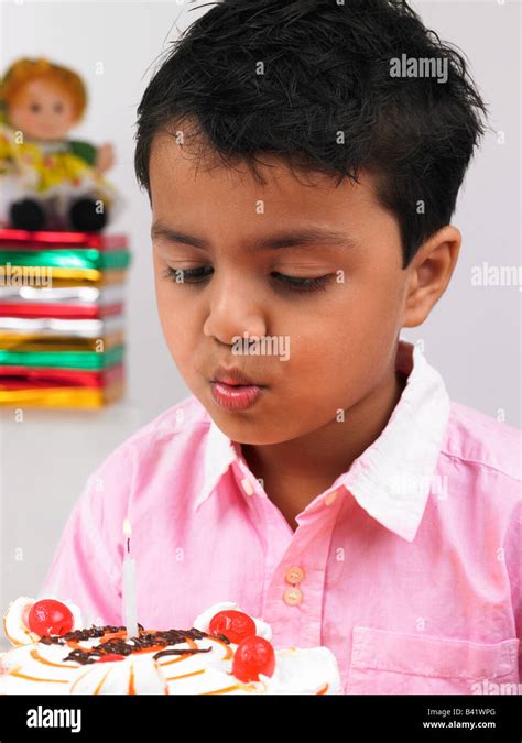 Asian Boy Blowing The Candle Of His Birthday Cake Hi Res Stock