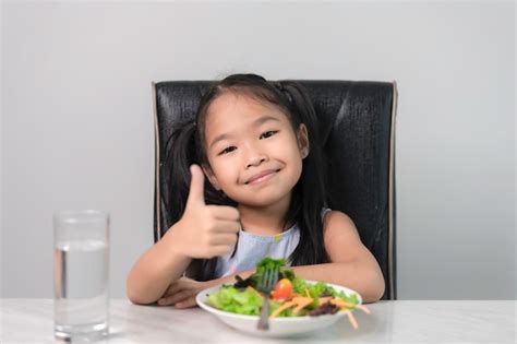 Premium Photo Little Asian Cute Girl To Eat Healthy Vegetablesnutrition And Healthy Eating