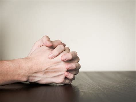 Premium Photo Hands Folded Together On The Table Praying Concept