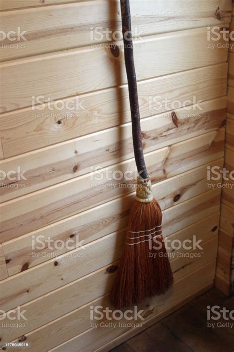 Old Fashioned Straw Broom Hanging On Shiplap Wood Wall Stock Photo