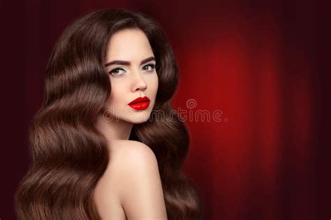 capelli di bellezza ritratto castana della ragazza con trucco e il lon rossi delle labbra