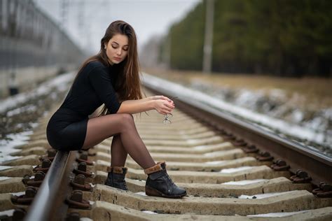 Model Sitting On The Railroad Tracks Holding Glasses In Her Hands 高清壁纸