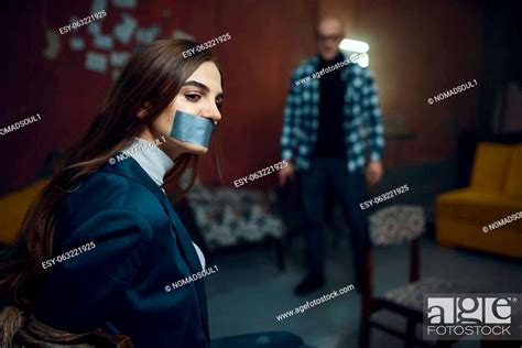 Maniac Kidnapper And Female Victim With Taped Mouth Shut Stock Photo