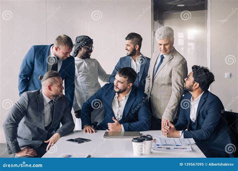 Portrait Of Business Men Only Meeting Around Table In Office Stock