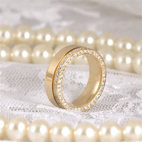 A Gold Ring Sitting On Top Of Pearls