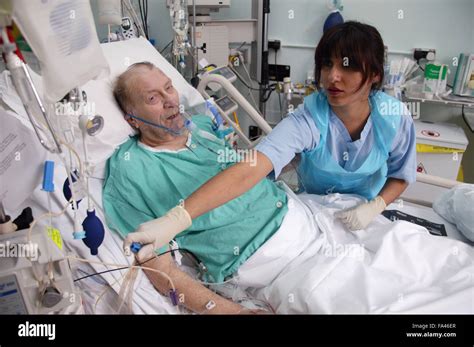Staff Nurse Attending To Patient In The Adult Intensive Care Unit Stock