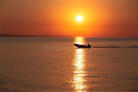 Sunrise On Sea With Fisherman Is Sailing Throught Sun Path Stock Image