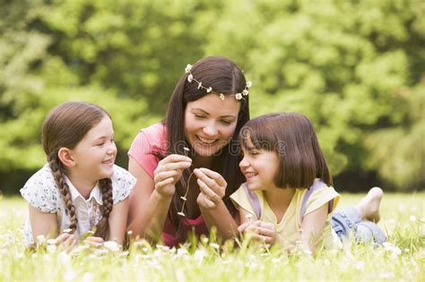 Madre E Hijas Que Mienten Al Aire Libre Con Las Flores Imagen De