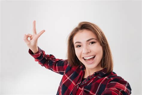 Close Up Portrait Of A Cute Lovely Woman Taking Selfie And Showing Peace Sign With Fingers Over
