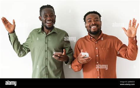 Two Black Guy Using Smartphones Waving Hands White Background