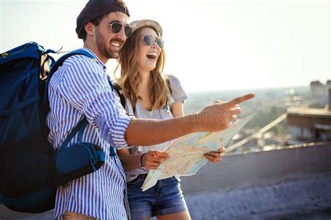 Happy Young Couple Of Travellers Holding Map In Hands Stock Photo