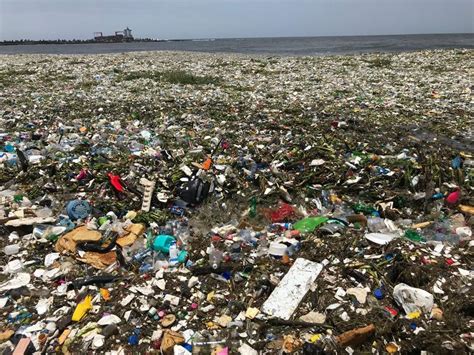 waves of garbage are washing onto a beach in the dominican republic waves tropical paradise