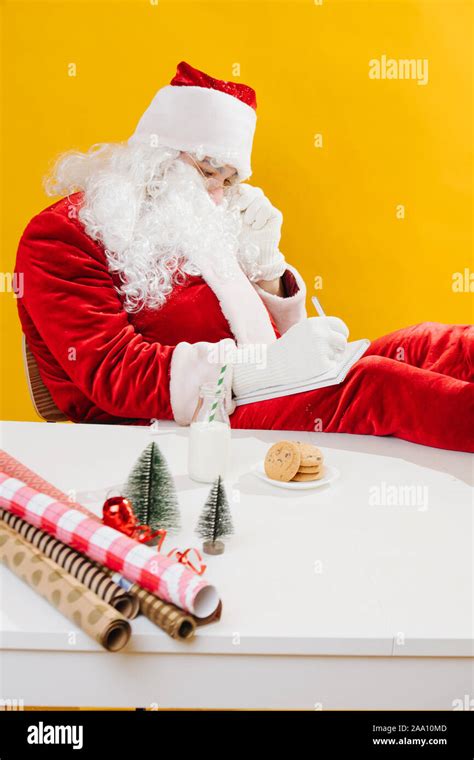 Santa Claus Put His Feet On The Table And Writes In A Notebook Stock Photo Alamy