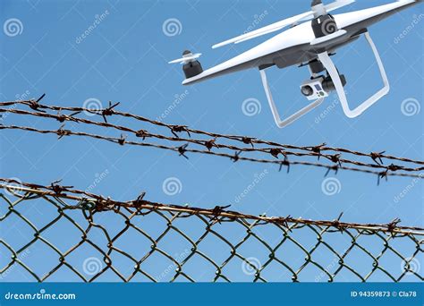 Drone With Digital Camera Flying Over A Barbed Wire Fence Stock