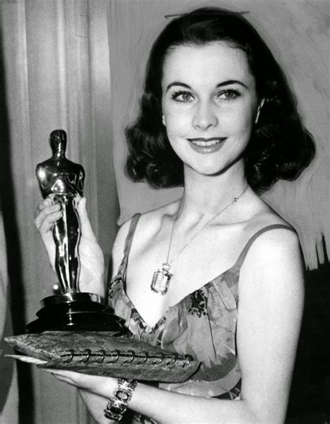 An Old Black And White Photo Of A Woman Holding Her Oscar Award For
