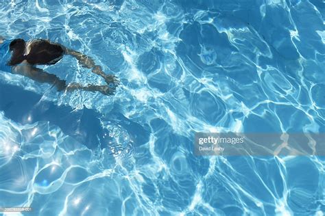 Girl Swimming Underwater In Pool Rear View Elevated View High Res Stock