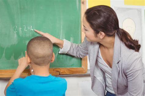 Pretty Teacher Helping Pupil At Chalkboard Stock Photo Image Of