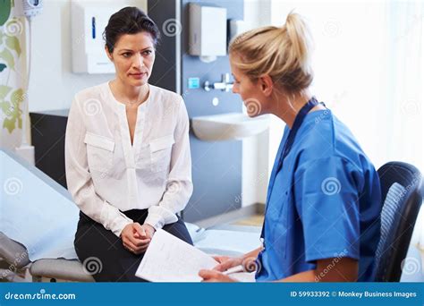 Female Patient And Doctor Have Consultation In Hospital Room Stock