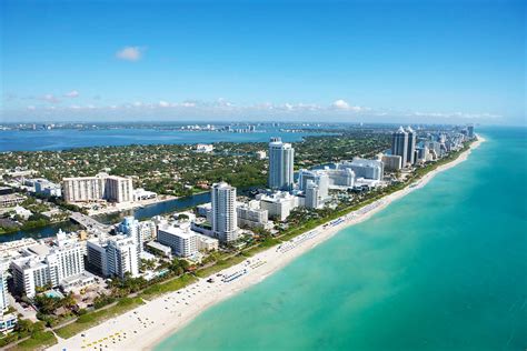 Aerial View Of Stunning Buildings Next To A White Beach At Miami Beach
