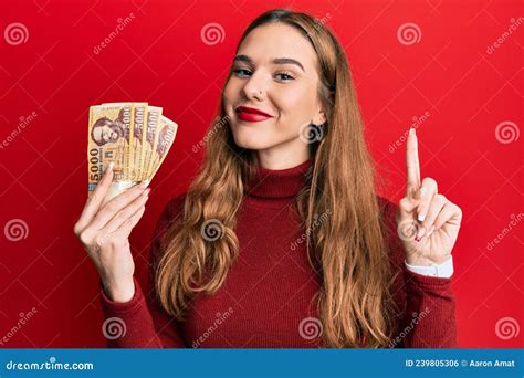 Young Blonde Woman Holding 5000 Hungarian Forint Banknotes Smiling With An Idea Or Question