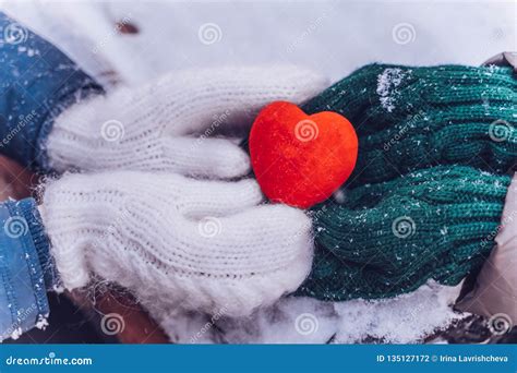 Hands In Gloves Holding Heart Closeup On Winter Snow Background Toned