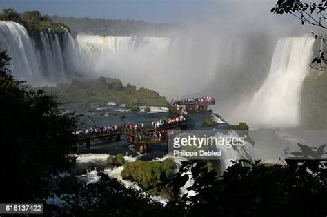 Viewing Platform With Tourists Over The Iguazu River And Panorama Of