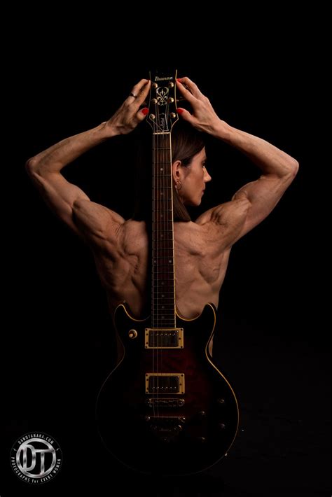 A Man With His Back To The Camera Holding An Electric Guitar In Front