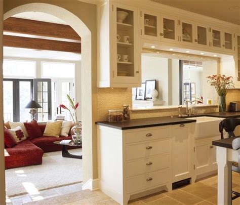 To make the kitchen feel less secluded, the homeowners opened a wall, moved a hallway door two feet towards the windows, and rotated the island 180 degrees, which helped expand the kitchen throughout the entire space. cutout between the rooms is another way to get that open ...