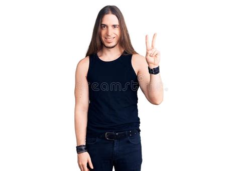 Young Adult Man With Long Hair Wearing Goth Style With Black Clothes Smiling Looking To The