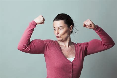 Proud Beautiful 40s Woman Admiring Her Flexing Muscles Stock Image