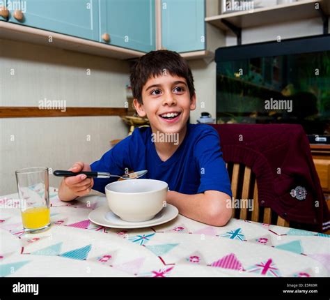 Boy Eating Cereal Breakfast At Table Stock Photo Alamy