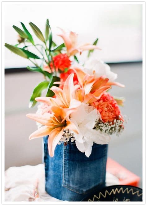 A Blue Vase Filled With Lots Of Flowers On Top Of A White Cloth Covered