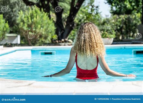 Blonde Vrouw Met Een Rode Badpak Op Haar Rug In Een Zwembad