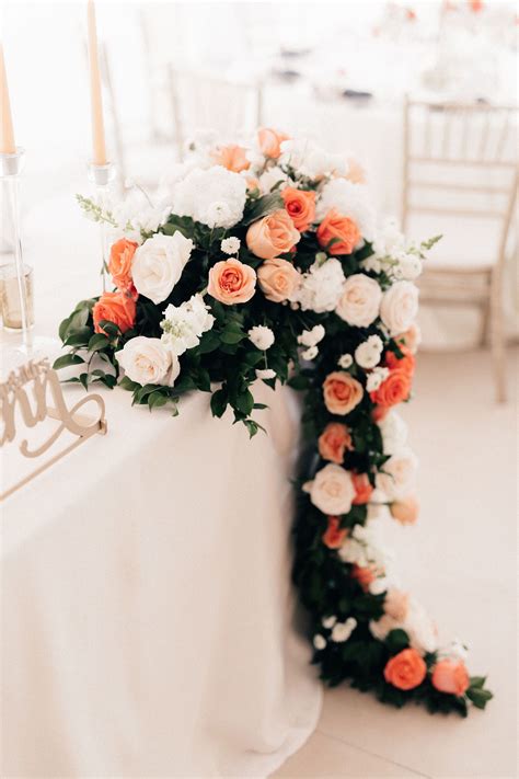 Coral and pink flowers for this wedding sweetheart table | Sweetheart