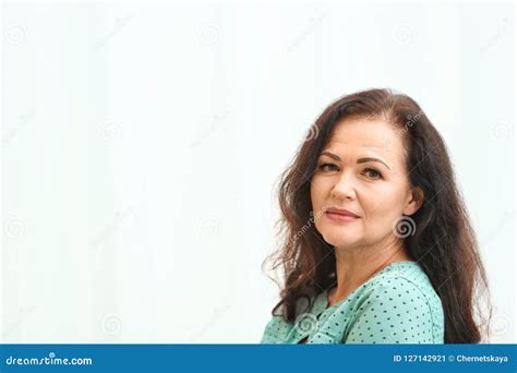 Portrait Of Beautiful Older Woman Against Light Background Stock Image