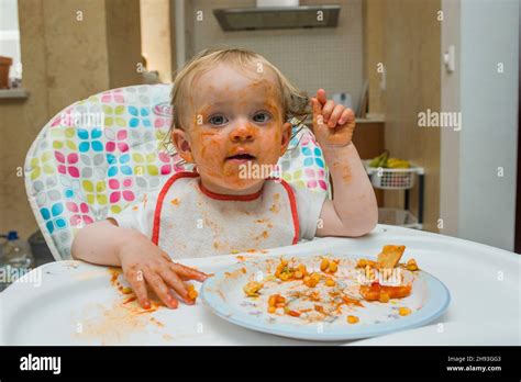 A Baby Girl Age 15 Months Eats A Meal Of Sweet Corn And Tomato Sauce