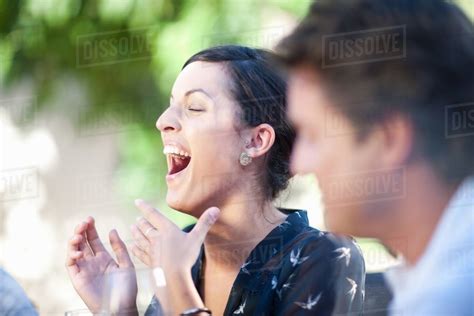 Woman Laughing At Table Outdoors Stock Photo Dissolve