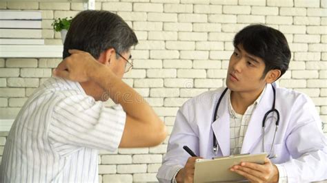 Asian Man Doctor Asking Health Problems Patient Questions And Taking
