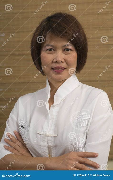 Mature Asian Supervisor Woman Cheerfully Talking To Employees Sitting