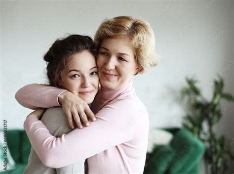 Lifestyle And People Concept Happy Senior Mother Embracing Adult Daughter Laughing Together
