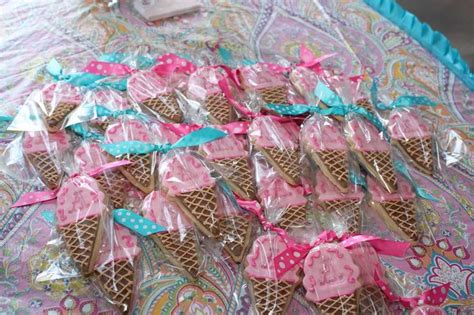 Ice Cream Cones Wrapped In Pink And Blue Plastic Wrappers With Bows On Them Sitting On A Table