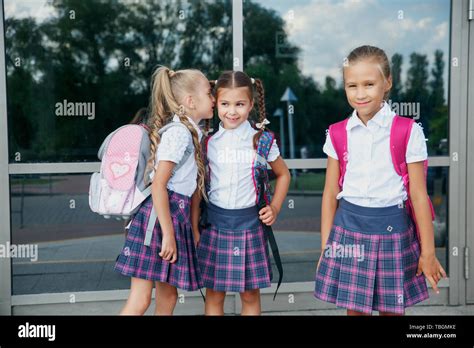 Pupils Of Primary School Girls With Backpacks Near Building Outdoors