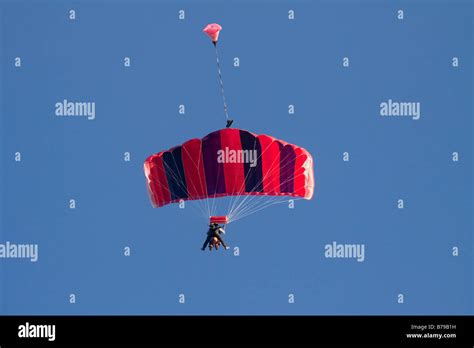 Red Striped Parachute Carrying Two People Glides The Blue Sky Hi Res