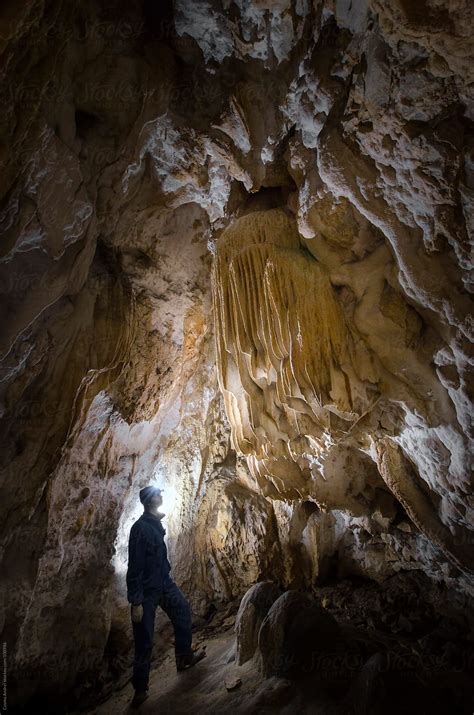 Explorer Looking At Limestone Formation Inside Cave By Stocksy