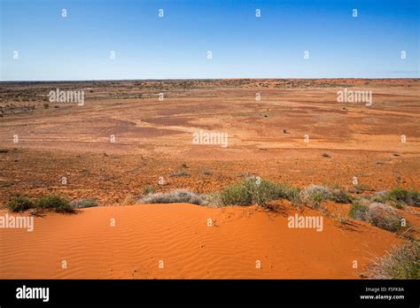 Vast Arid Desert Landscape Of Red Sand Dunes And Vast Barren Treeless
