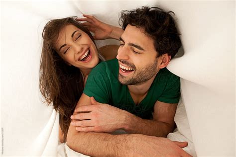 Young Carefree Couple Laughing And Enjoying Morning In Bed By Stocksy Contributor Mosuno