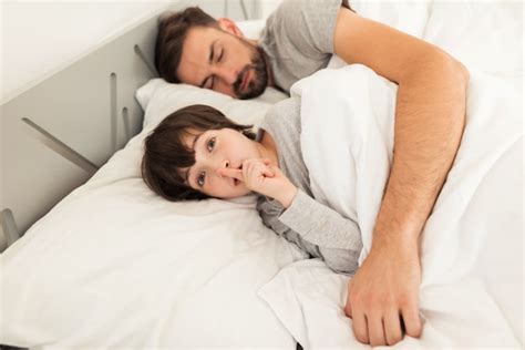 Pequeño Hijo Con El Padre Durmiente Cansado En Cama Foto Premium