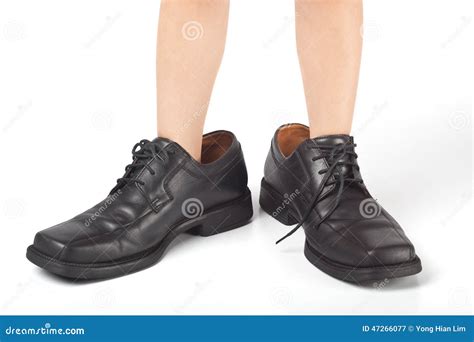 Big Shoes To Fill Childs Feet In Large Black Shoes Stock Photo
