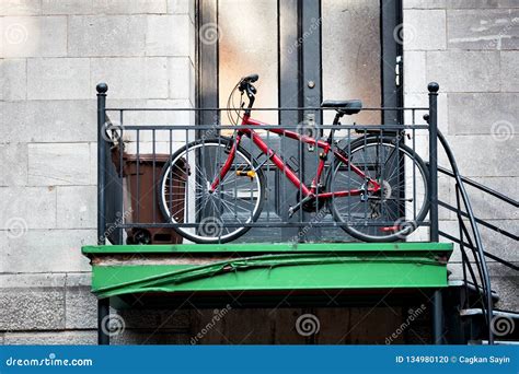 Red City Bicycle Parked In Front Of An Old Apartment Door Next To The