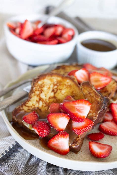 French Toast With Syrup And Strawberries On A Plate